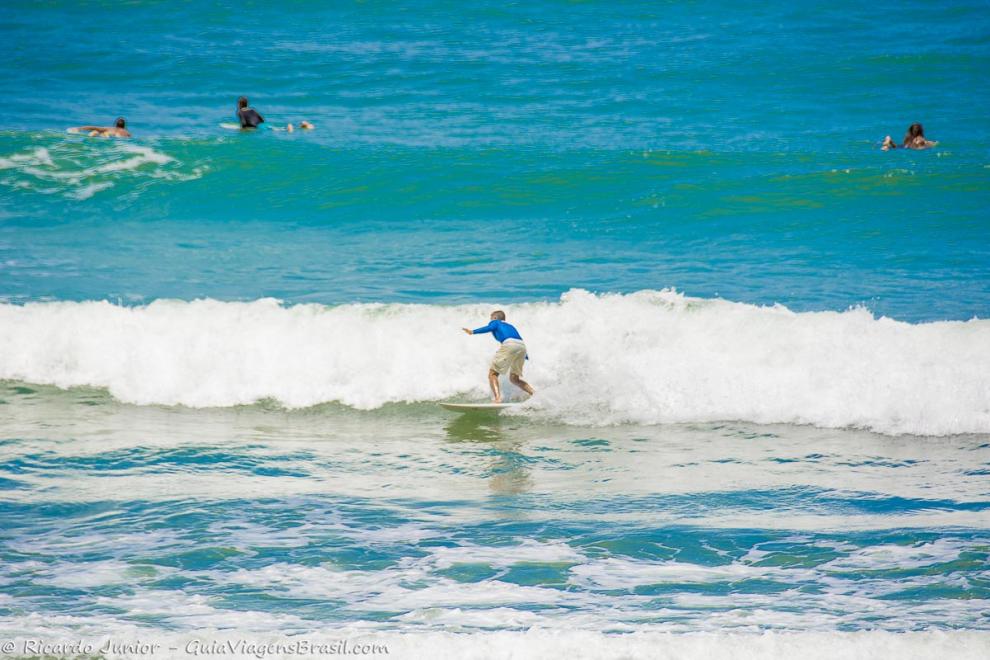 Imagem de surfistas aproveitando as ondas.